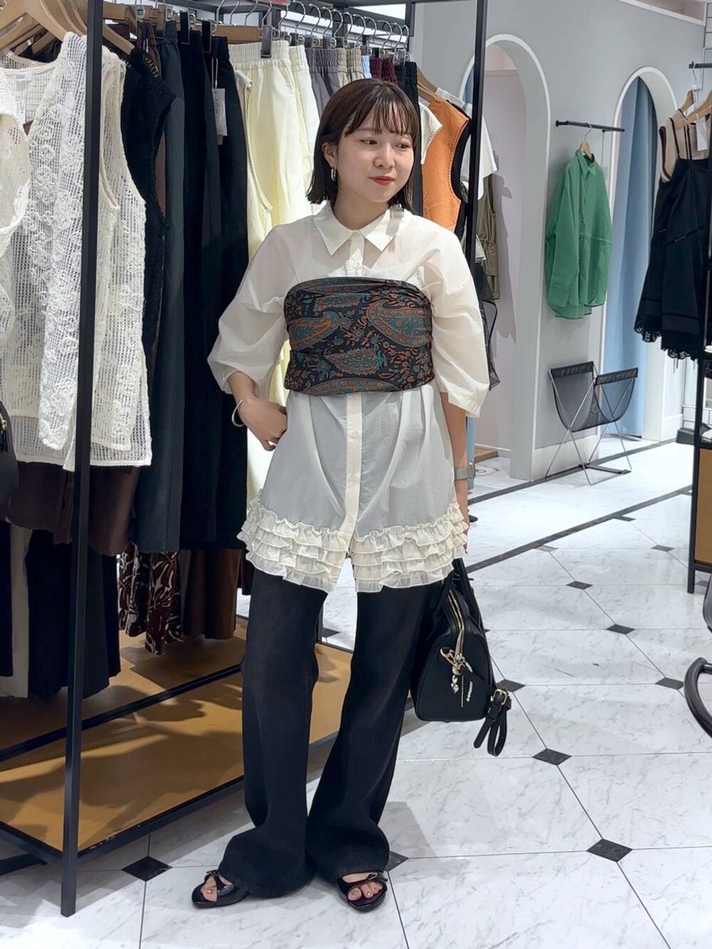 ブラック系のサンダル、ブラック系のショルダーバッグ、ブラック系のデニムパンツを着用したレディースの夏コーディネートの3枚目の写真