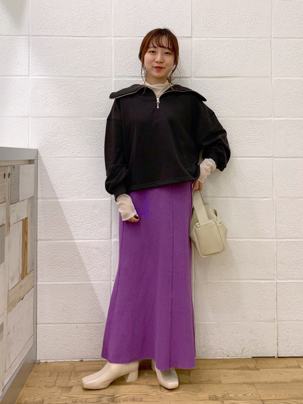 グレー系のトップス、ホワイト系のトップス、パープル系のスカートを着用したレディースの秋コーディネートの2枚目の写真