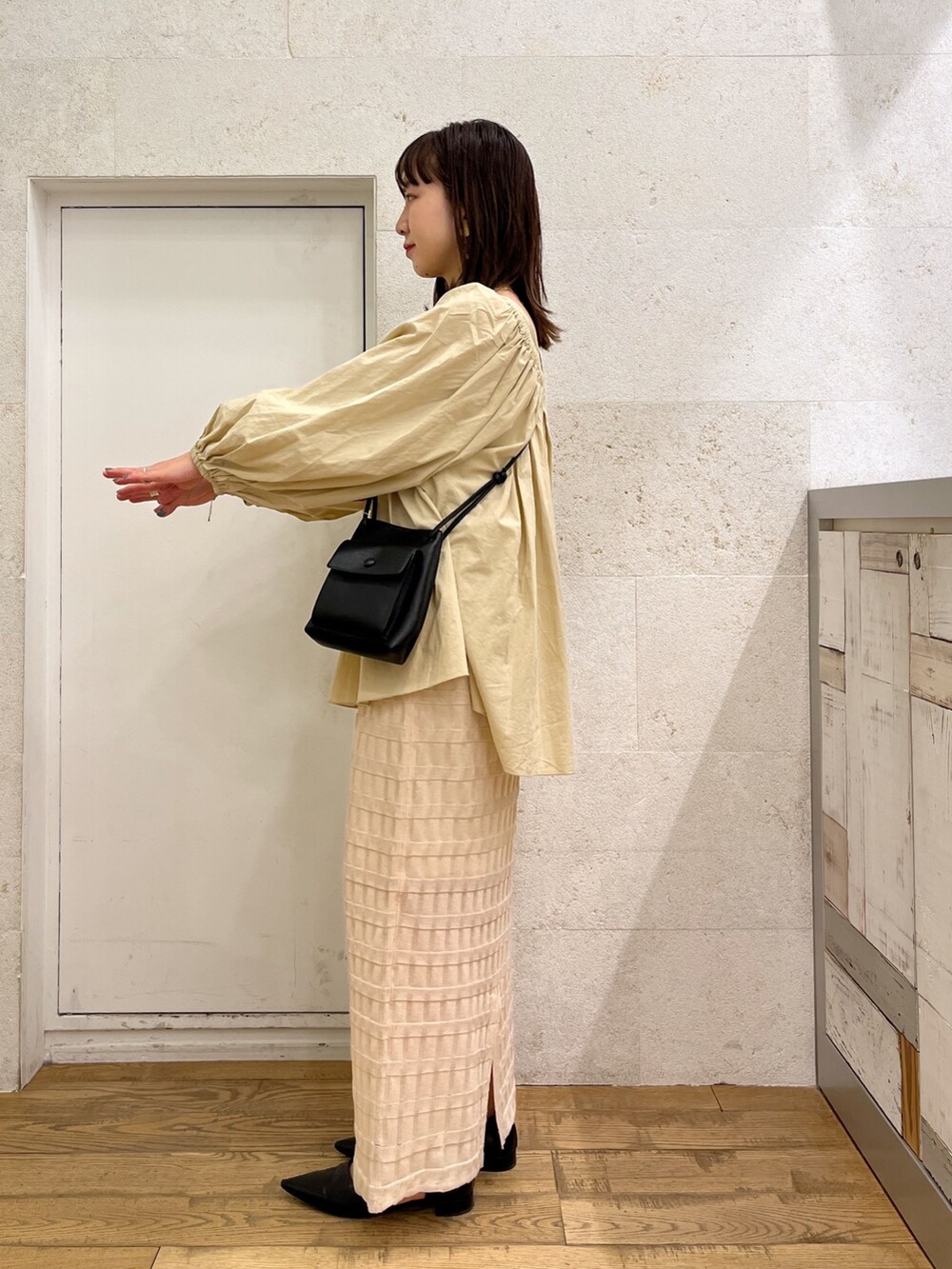 ブラウン系のシャツ/ブラウス、ホワイト系のバッグ、ブラック系のスカートを着用したレディースの春コーディネートの3枚目の写真