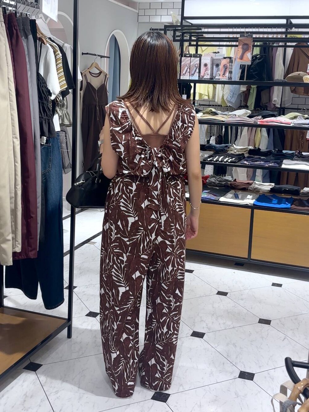 ブラウン系のTシャツ/カットソー、ホワイト系のサンダル、ベージュ系のサロペット/オーバーオールを着用したレディースの夏コーディネートの3枚目の写真
