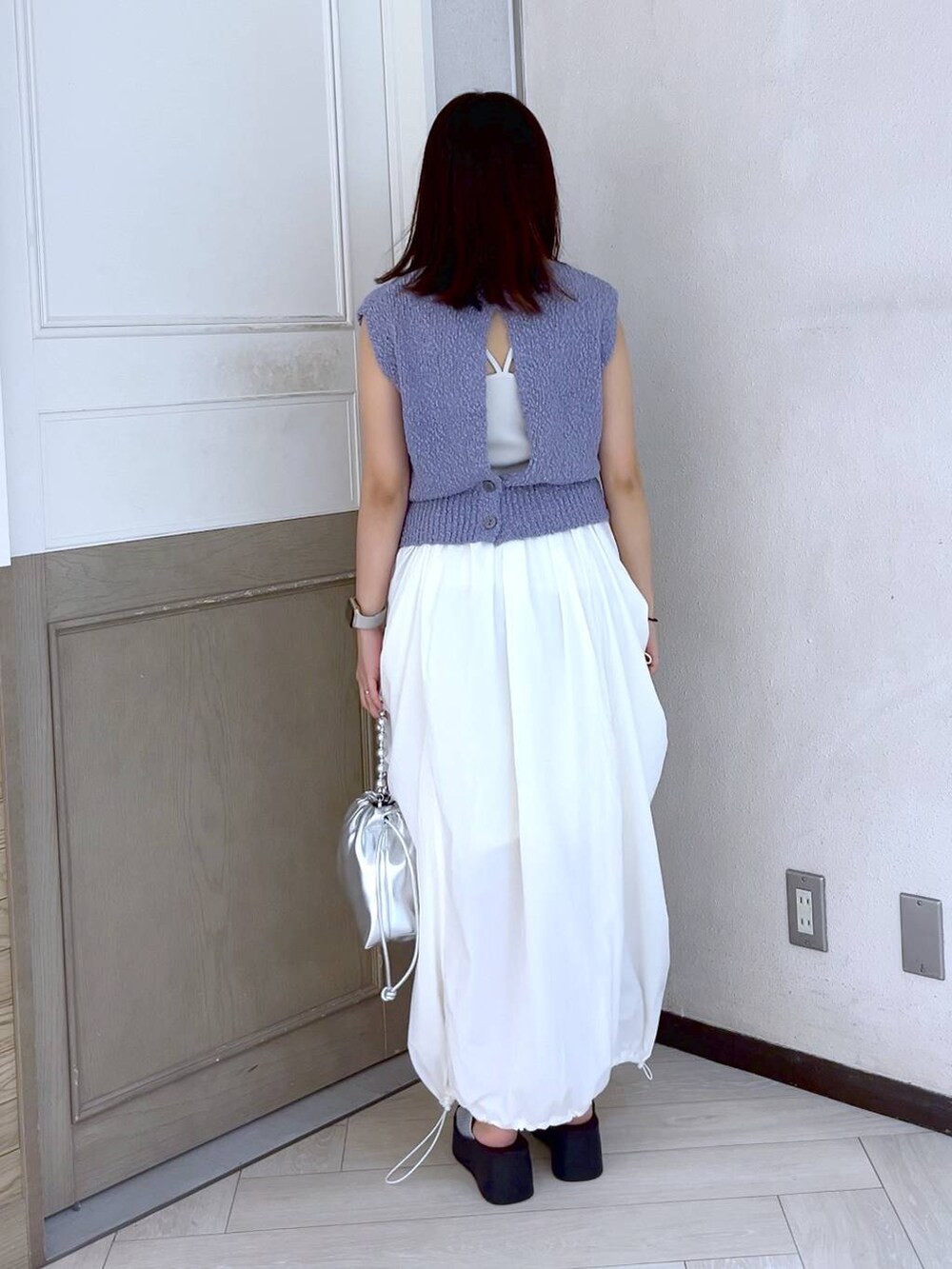 シルバー系のサンダル、ホワイト系のスカート、シルバー系のショルダーバッグを着用したレディースの夏コーディネートの4枚目の写真