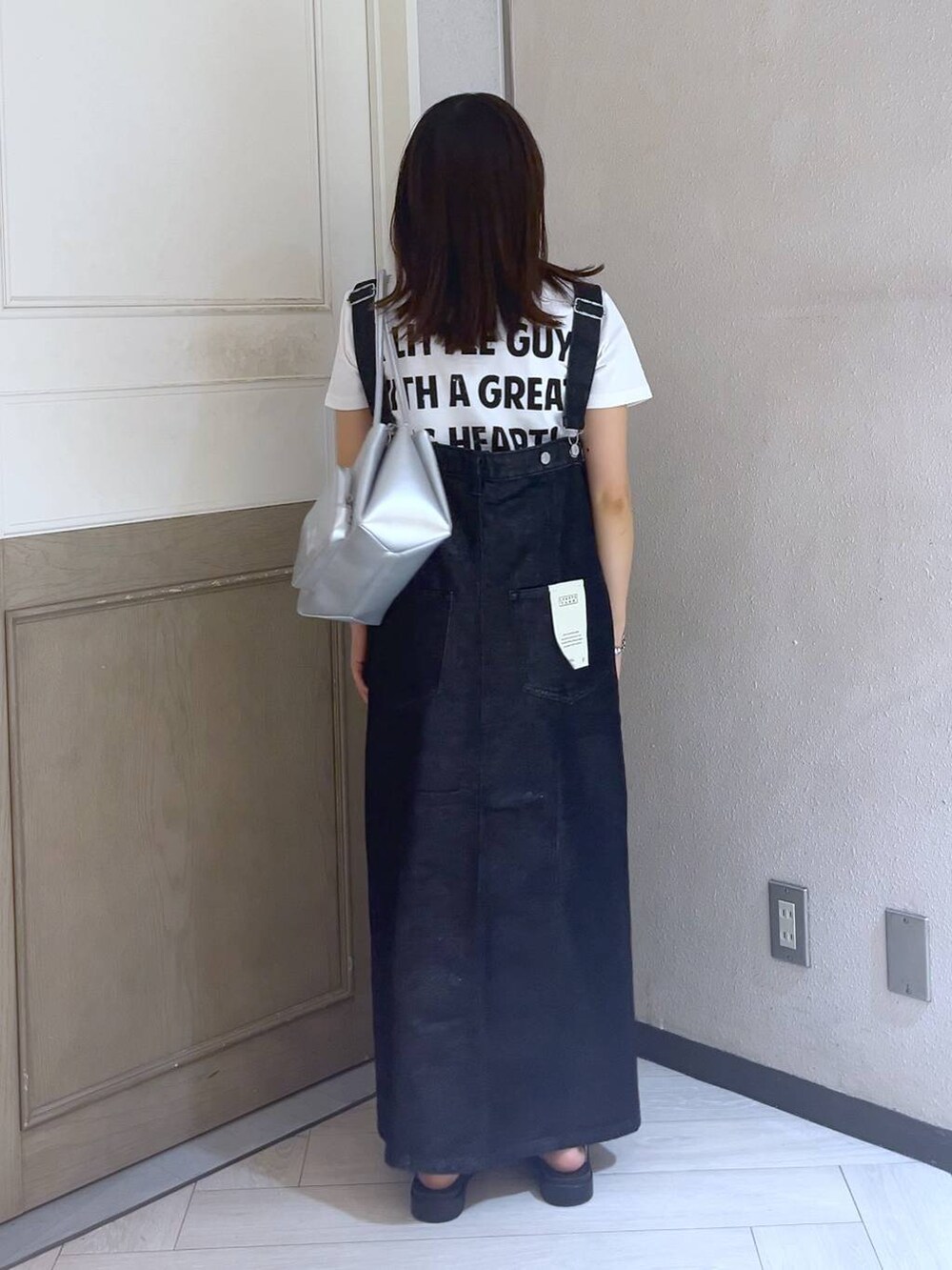 ブラック系のジャンパースカート、シルバー系のスニーカー、シルバー系のショルダーバッグを着用したレディースの夏コーディネートの4枚目の写真