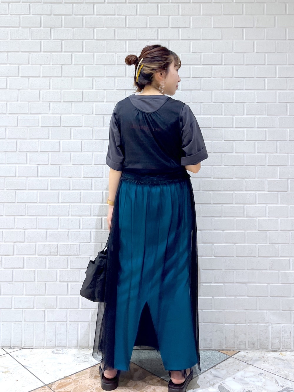 グレー系のTシャツ/カットソー、ブラック系のワンピース、ブルー系のスカートを着用したレディースの春コーディネートの5枚目の写真