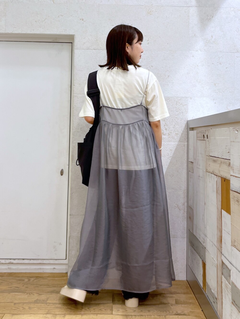 グレー系のワンピース、ホワイト系のシューズ、ブラック系のバッグを着用したレディースの夏コーディネートの4枚目の写真