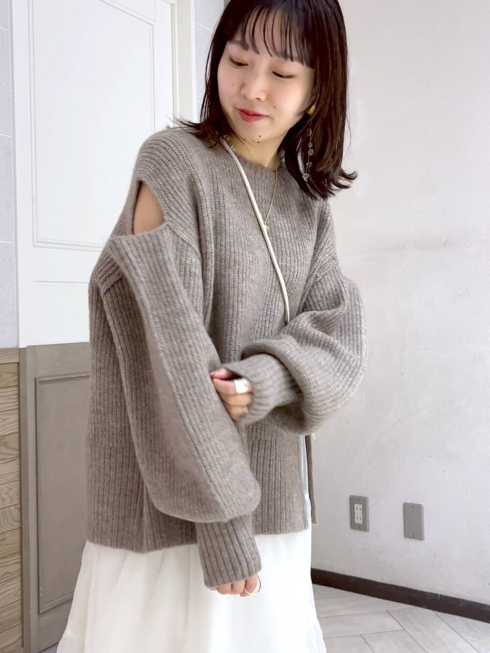 ホワイト系のショルダーバッグ、ブラック系のブーツ、ホワイト系のスカートを着用したレディースの秋コーディネートの6枚目の写真