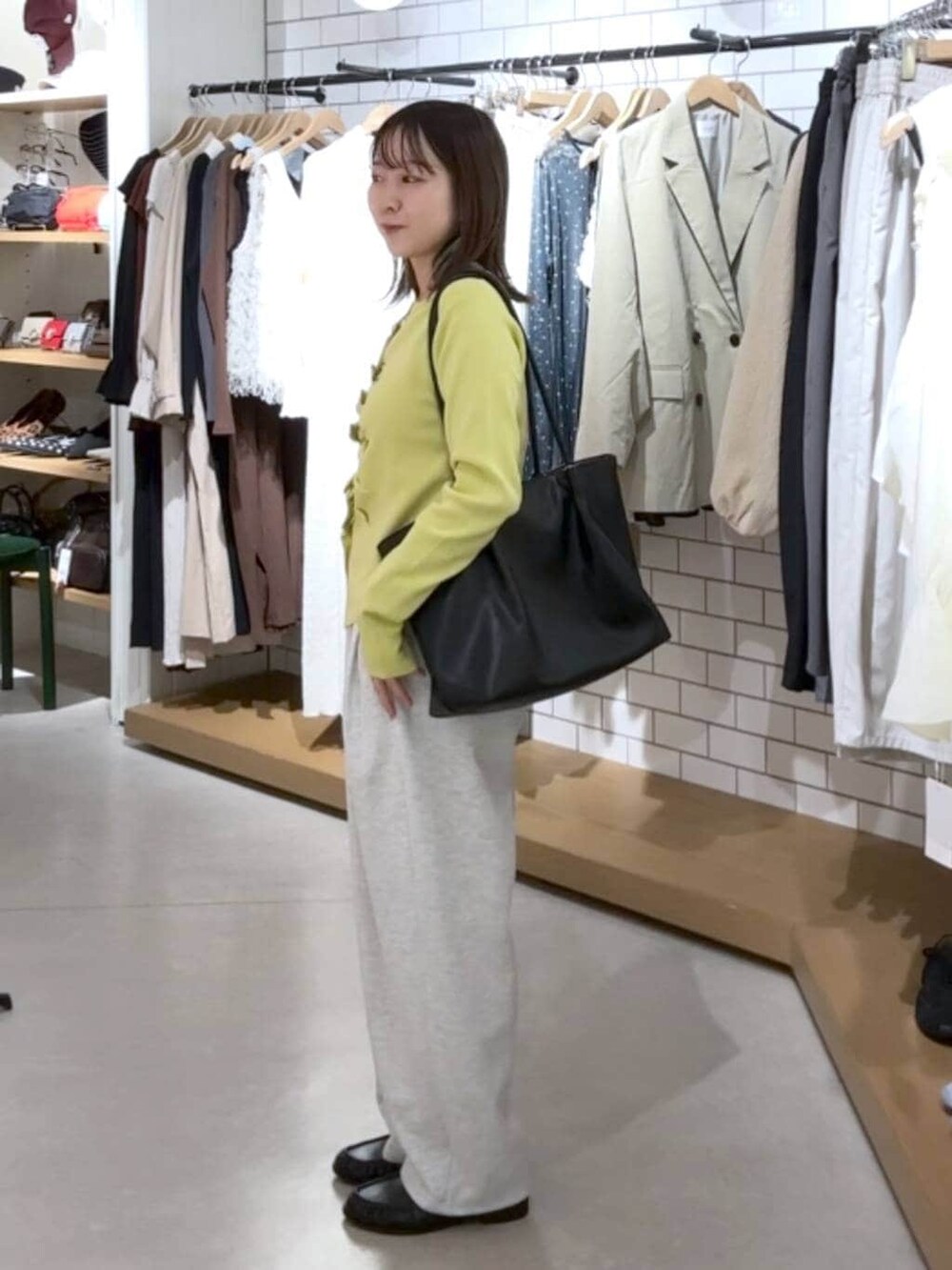 グレー系のスウェットパンツ、ブラック系のローファー、イエロー系のカーディガン/ボレロを着用したレディースの春コーディネートの3枚目の写真