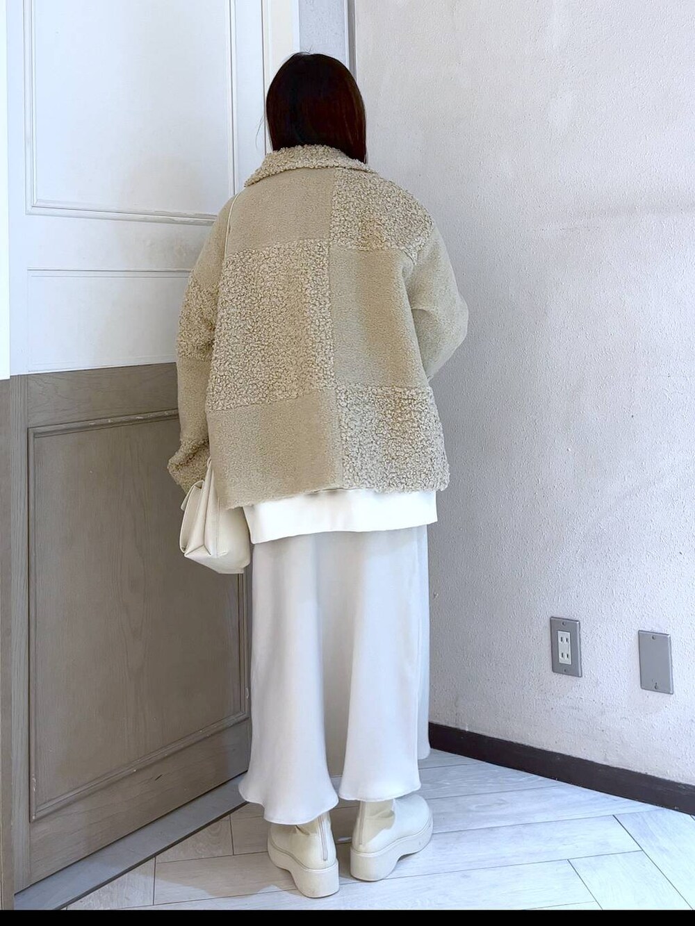 ホワイト系のスウェット、ホワイト系のショルダーバッグ、ホワイト系のスカートを着用したレディースの冬コーディネートの3枚目の写真