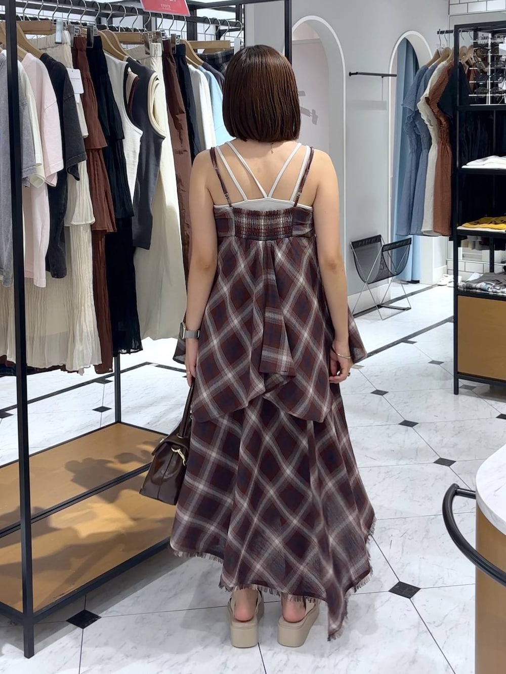 ホワイト系のTシャツ/カットソー、ホワイト系のサンダル、レッド系のスカートを着用したレディースの夏コーディネートの2枚目の写真