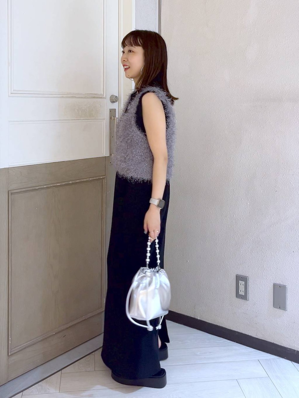 グレー系のキャミソール、ブラック系のワンピース、シルバー系のサンダルを着用したレディースの夏コーディネートの3枚目の写真