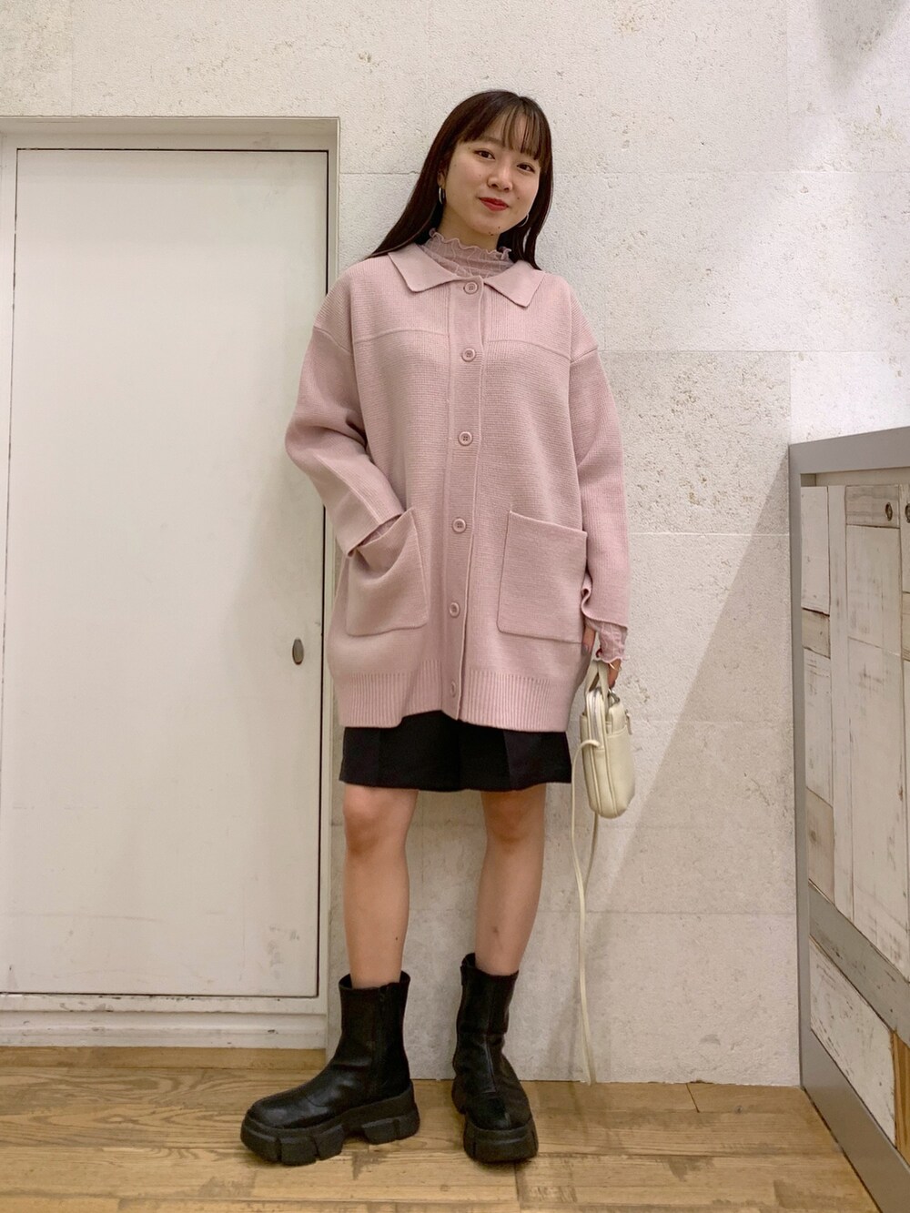 ピンク系のカーディガン/ボレロ、ブラック系のパンツ、ブラック系のバッグを着用したレディースの冬コーディネートの2枚目の写真