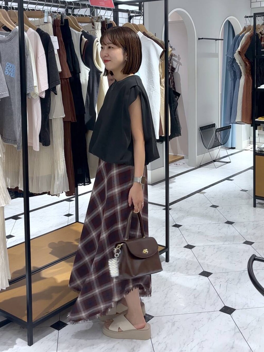 ホワイト系のサンダル、ブラウン系のボストンバッグ、グレー系のTシャツ/カットソーを着用したレディースの夏コーディネートの2枚目の写真