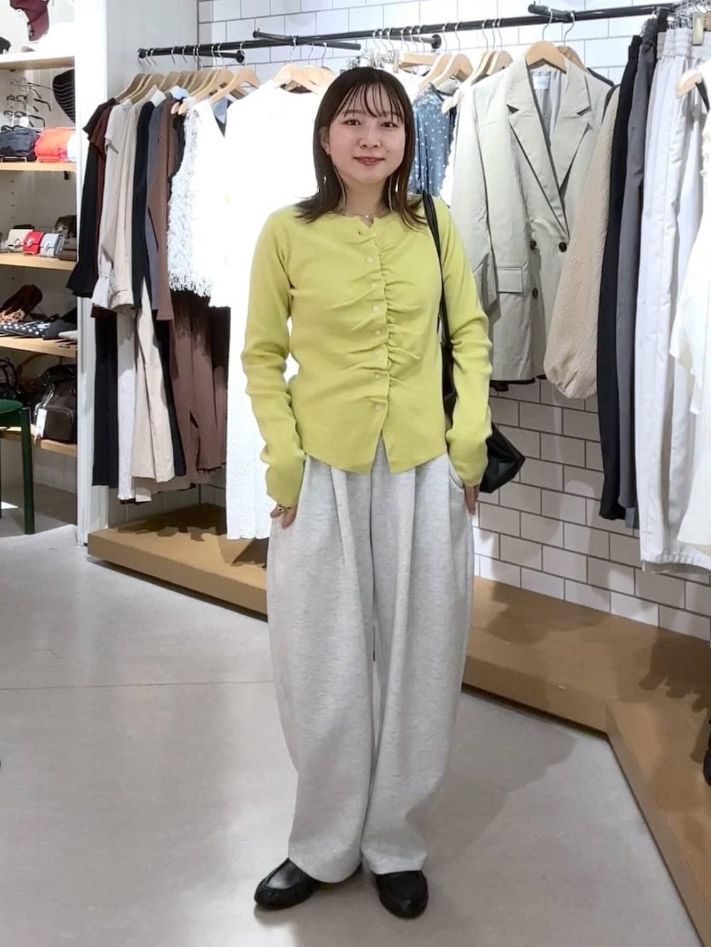 グレー系のスウェットパンツ、ブラック系のローファー、イエロー系のカーディガン/ボレロを着用したレディースの春コーディネートの2枚目の写真