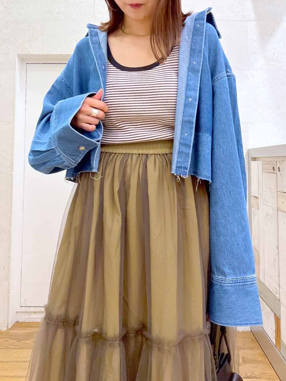 ブルー系のシャツ/ブラウス、グリーン系のスカート、ブラック系のトップスを着用したレディースの秋コーディネートの4枚目の写真