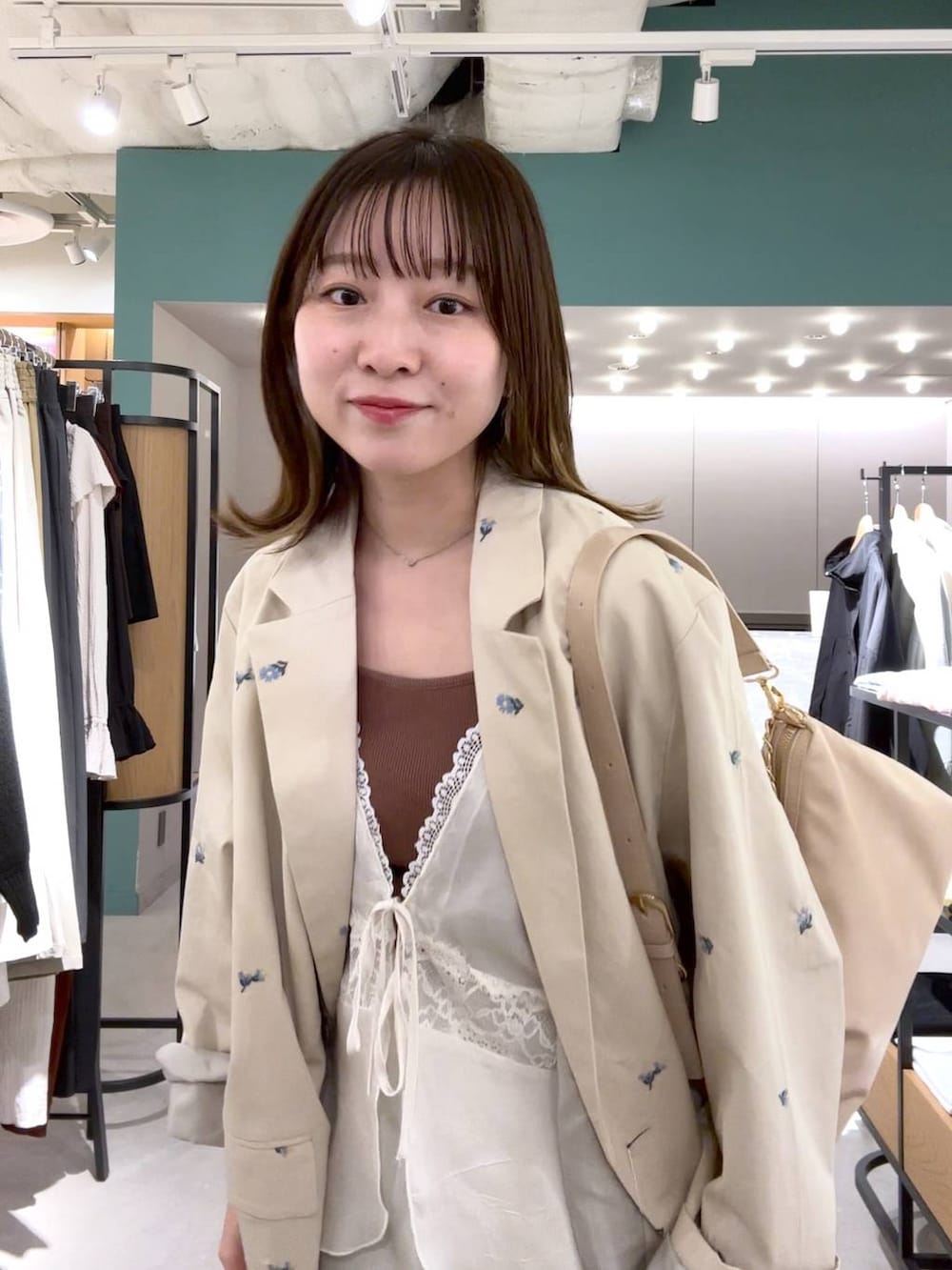 ホワイト系のスカート、ホワイト系のパンプス、ホワイト系のベストを着用したレディースの春コーディネートの2枚目の写真