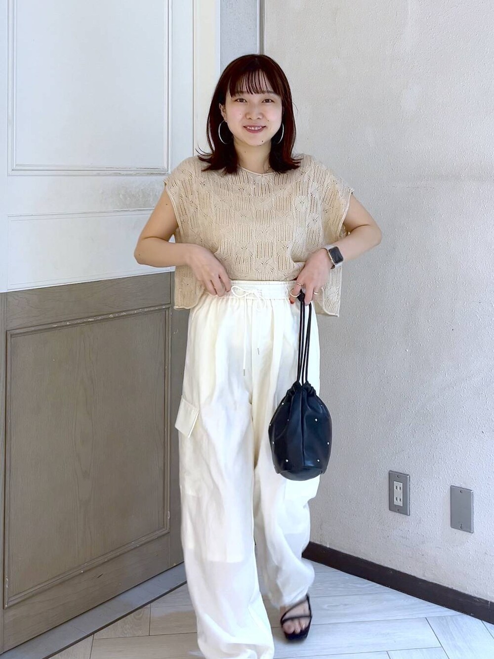 ホワイト系のカーゴパンツ、ブラック系のショルダーバッグ、ブラック系のサンダルを着用したレディースの夏コーディネートの6枚目の写真