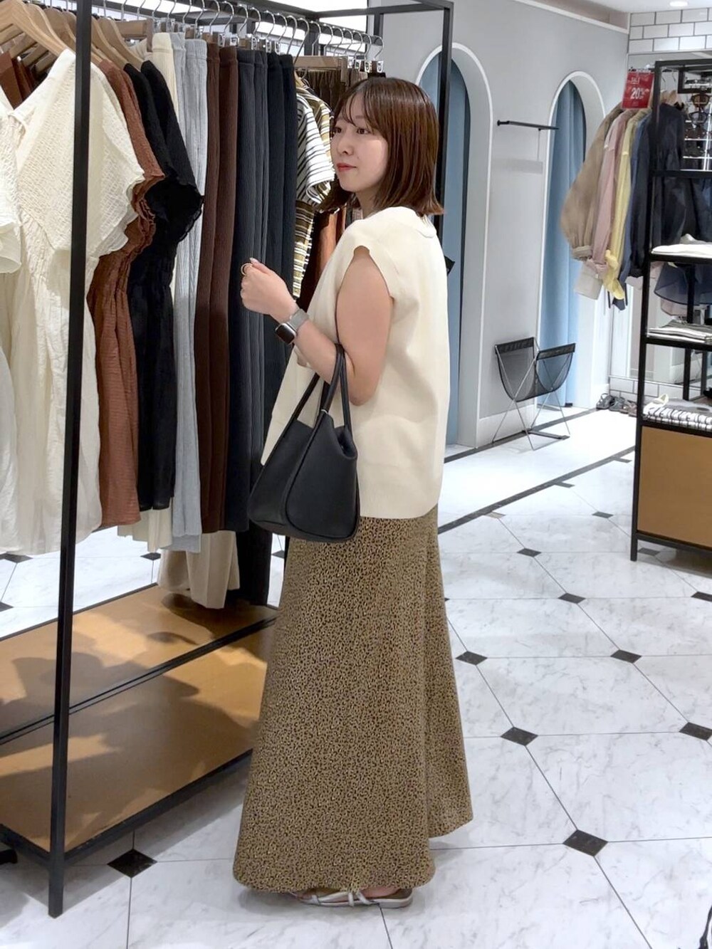 ブラウン系のTシャツ/カットソー、シルバー系のサンダル、その他のスカートを着用したレディースの夏コーディネートの2枚目の写真