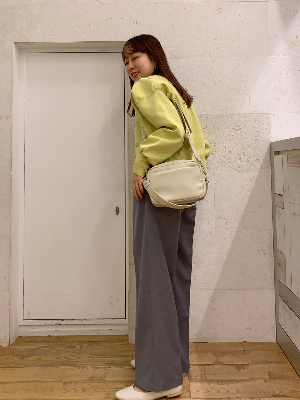 イエロー系のカーディガン/ボレロ、ブラック系のトップス、グレー系のパンツを着用したレディースの春コーディネートの2枚目の写真