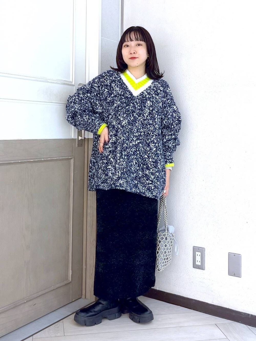 ブラック系のブーツ、ブルー系のニット/セーター、ホワイト系のショルダーバッグを着用したレディースの秋コーディネートの2枚目の写真