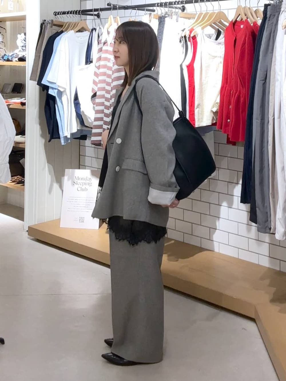ブラック系のパンプス、グレー系のテーラードジャケット、グレー系のデニムパンツを着用したレディースの春コーディネートの2枚目の写真