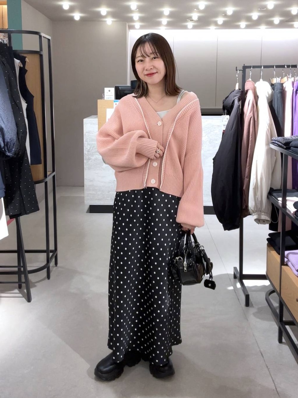 ホワイト系のTシャツ/カットソー、ブラック系のブーツ、ブラック系のスカートを着用したレディースの冬コーディネートの2枚目の写真