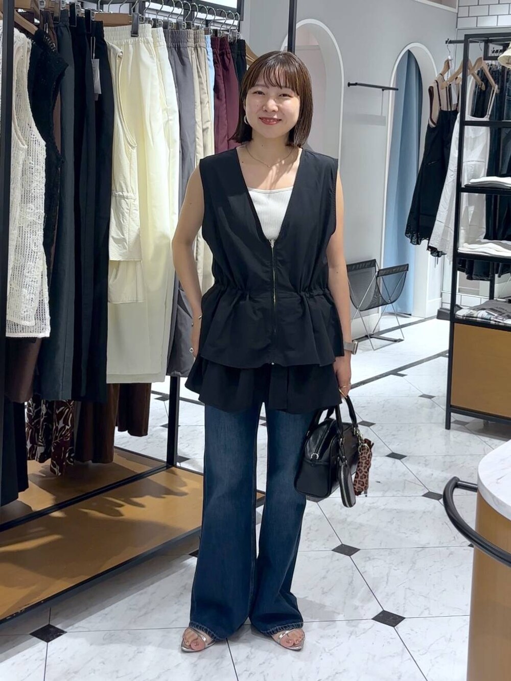 ホワイト系のTシャツ/カットソー、シルバー系のサンダル、ブラック系のショルダーバッグを着用したレディースの夏コーディネートの2枚目の写真