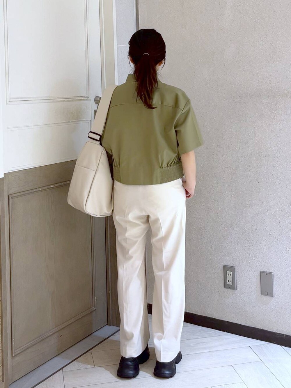 ブラック系のサンダル、ホワイト系のボディバッグ/ウエストポーチ、ホワイト系のスラックスを着用したレディースの春コーディネートの3枚目の写真