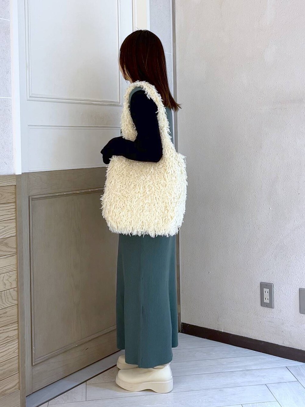 ホワイト系のブーツ、グリーン系のワンピース、ホワイト系のトートバッグを着用したレディースの冬コーディネートの2枚目の写真