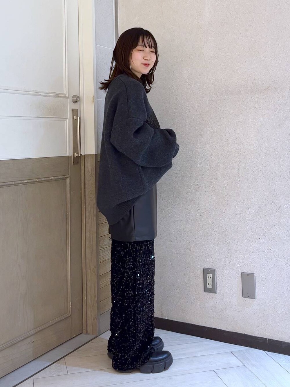 ブラック系のブーツ、シルバー系のボストンバッグ、ブラック系のスカートを着用したレディースの冬コーディネートの3枚目の写真