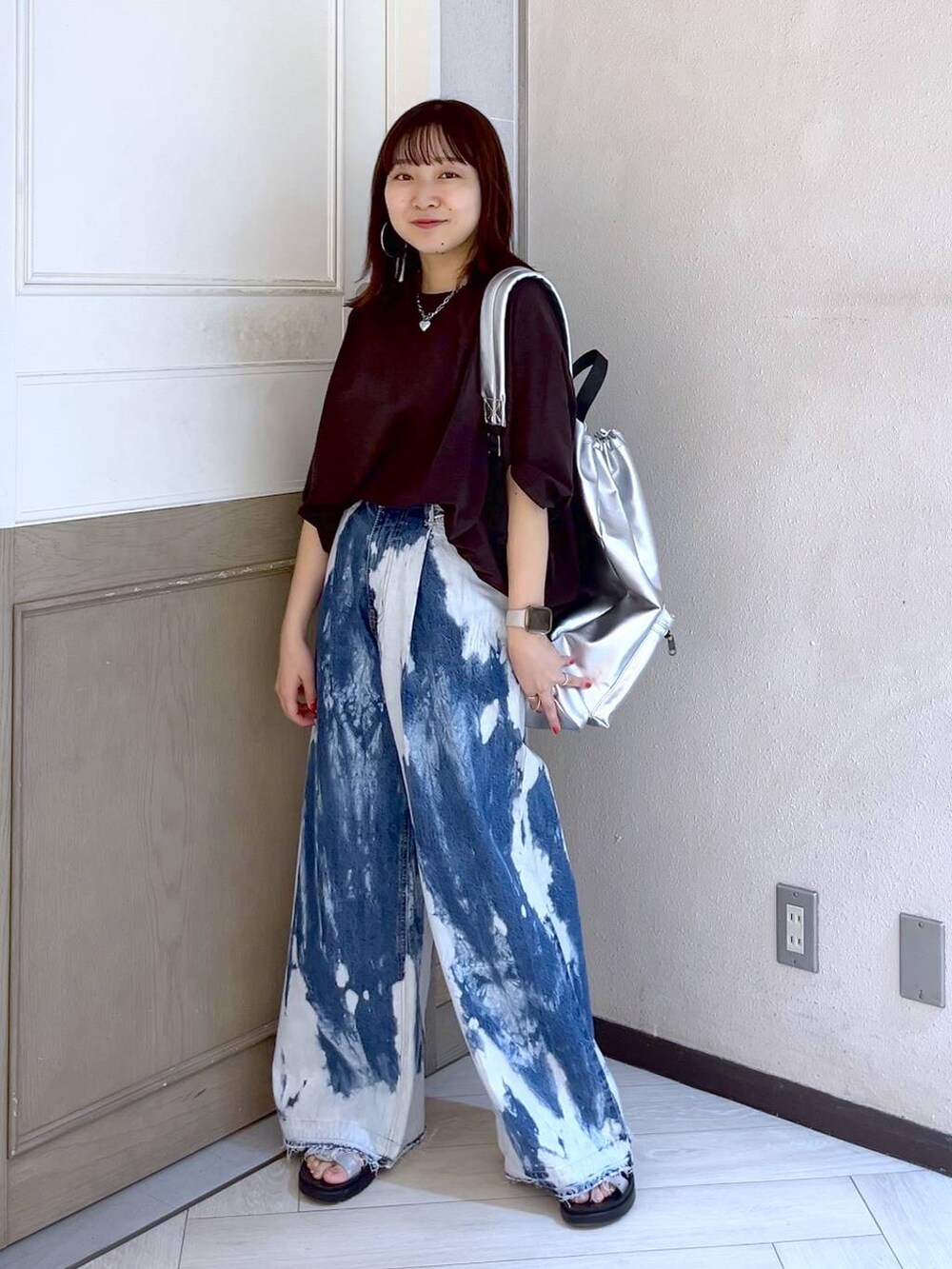 ブルー系のデニムパンツ、シルバー系のスニーカー、ブラウン系のTシャツ/カットソーを着用したレディースの夏コーディネートの3枚目の写真