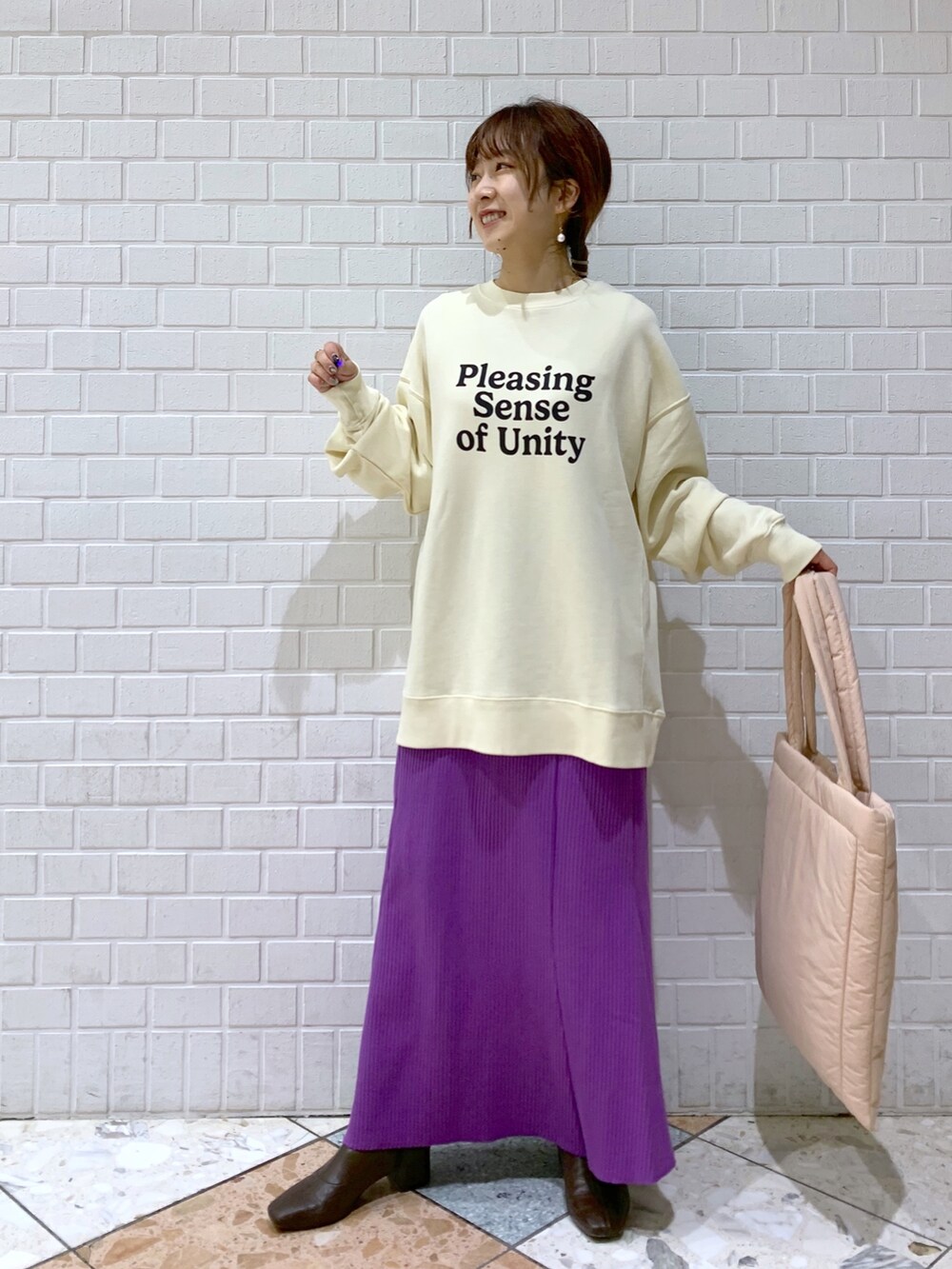 ホワイト系のスウェット、パープル系のスカート、ピンク系のショルダーバッグを着用したレディースの秋コーディネートの2枚目の写真