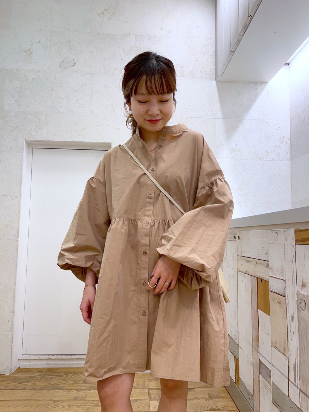 ベージュ系のトップス、ホワイト系のショルダーバッグ、ホワイト系のシューズを着用したレディースの春コーディネートの2枚目の写真