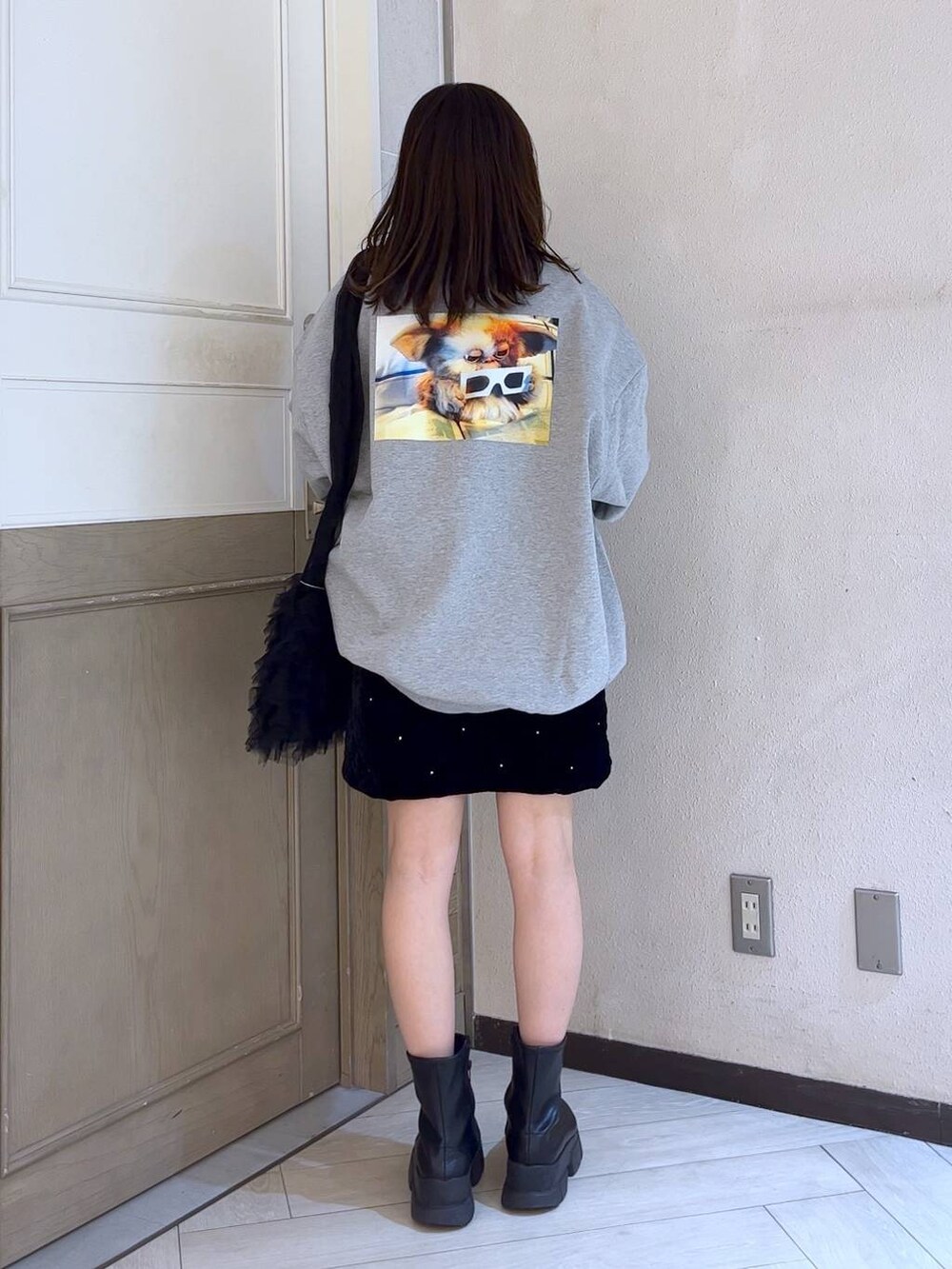 ブラック系のブーツ、レッド系のニット/セーター、ブラック系のショルダーバッグを着用したレディースの冬コーディネートの3枚目の写真