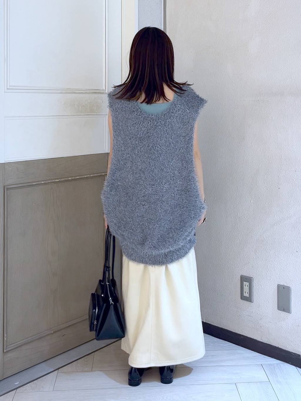 ブラック系のパンプス、グレー系のベスト、ブルー系のタンクトップを着用したレディースの夏コーディネートの4枚目の写真