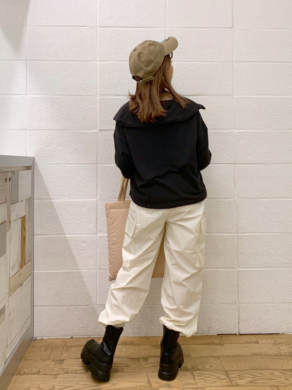 グレー系のトップス、ホワイト系のパンツ、ピンク系のショルダーバッグを着用したレディースの秋コーディネートの5枚目の写真