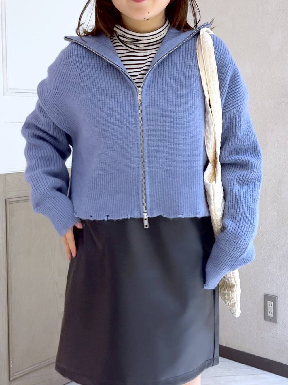 ホワイト系のTシャツ/カットソー、ホワイト系のトートバッグ、ブラック系のブーツを着用したレディースの冬コーディネートの4枚目の写真