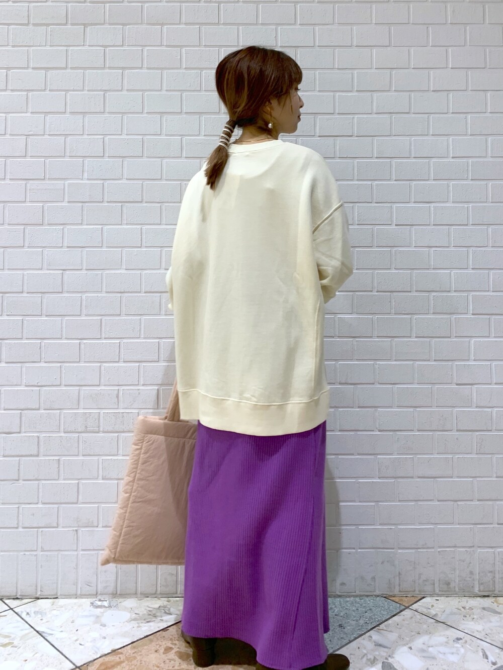 ホワイト系のスウェット、パープル系のスカート、ピンク系のショルダーバッグを着用したレディースの秋コーディネートの4枚目の写真