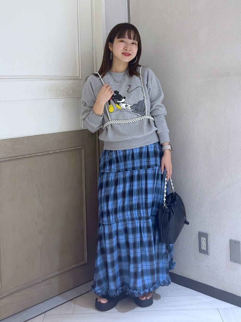 ブラック系のサンダル、ブルー系のスカート、グレー系のスウェットを着用したレディースの夏コーディネートの2枚目の写真