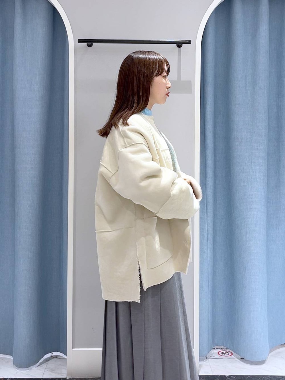 ブルー系のニット/セーター、ブラック系のブーツ、ブラック系のショルダーバッグを着用したレディースの冬コーディネートの4枚目の写真