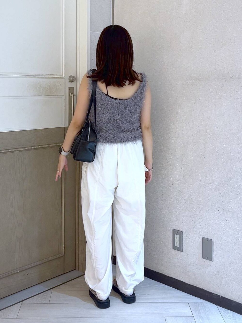 ホワイト系のカーゴパンツ、ブラック系のボストンバッグ、シルバー系のスニーカーを着用したレディースの夏コーディネートの4枚目の写真