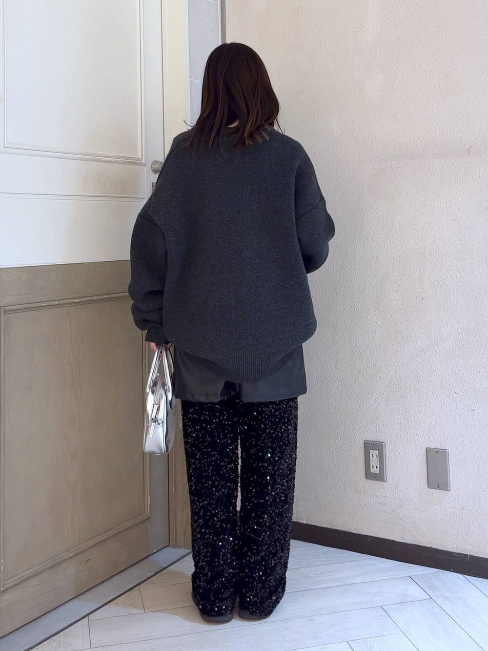 ブラック系のブーツ、シルバー系のボストンバッグ、ブラック系のスカートを着用したレディースの冬コーディネートの4枚目の写真