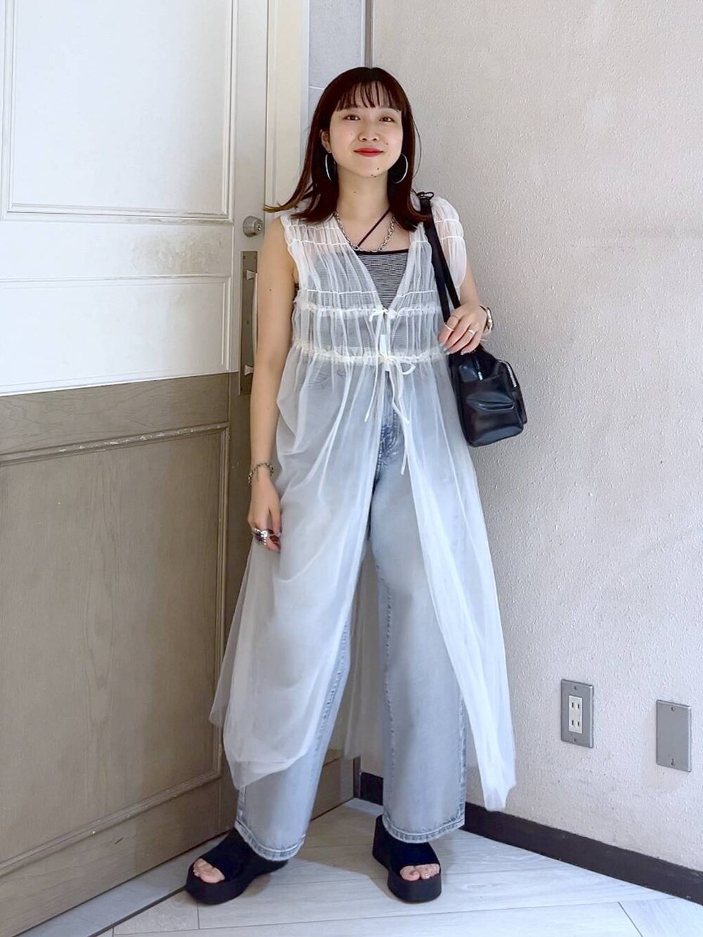 ブラック系のサンダル、ブルー系のデニムパンツ、その他のキャミソールを着用したレディースの夏コーディネートの2枚目の写真