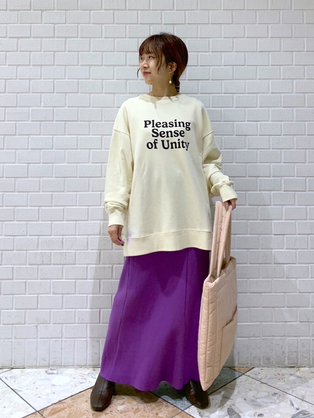 ホワイト系のスウェット、パープル系のスカート、ピンク系のショルダーバッグを着用したレディースの秋コーディネートの3枚目の写真