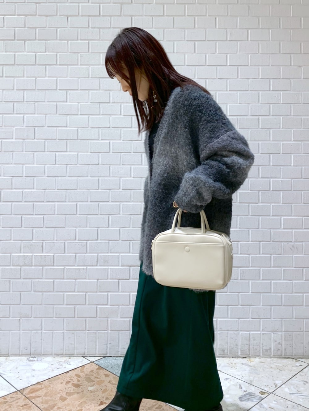 ブラック系のトップス、ブラック系のニット/セーター、グリーン系のスカートを着用したレディースの冬コーディネートの2枚目の写真