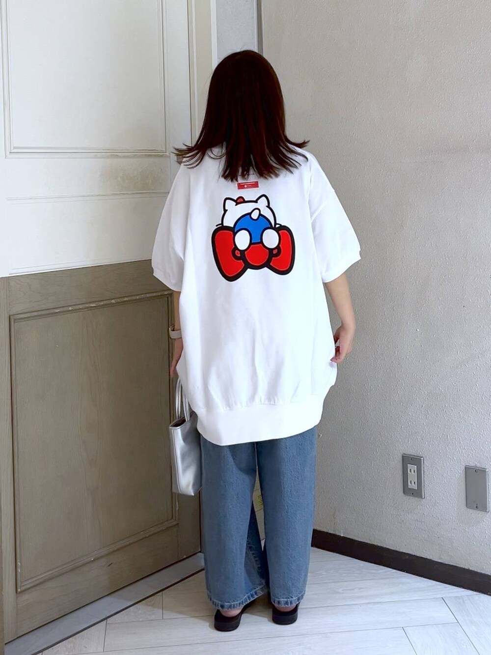 シルバー系のショルダーバッグ、ブルー系のデニムパンツ、シルバー系のサンダルを着用したレディースの夏コーディネートの4枚目の写真