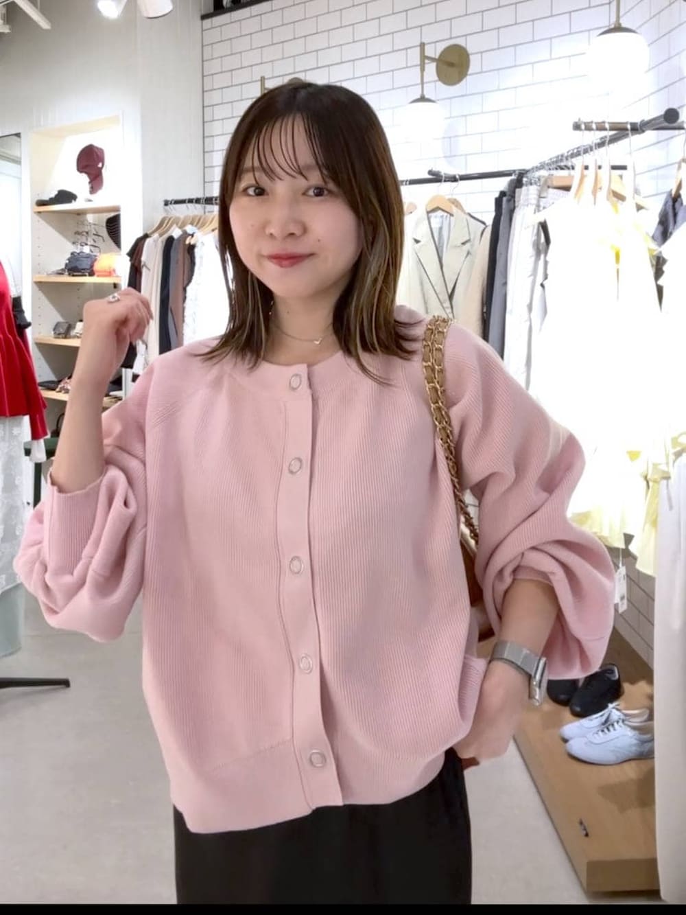 ブラック系のスカート、ベージュ系のショルダーバッグ、ブラック系のパンプスを着用したレディースの春コーディネートの3枚目の写真