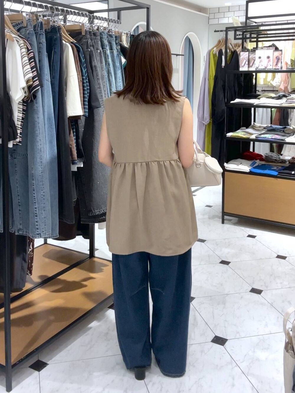 ホワイト系のTシャツ/カットソー、ブルー系のデニムパンツ、ブラック系のサンダルを着用したレディースの夏コーディネートの3枚目の写真