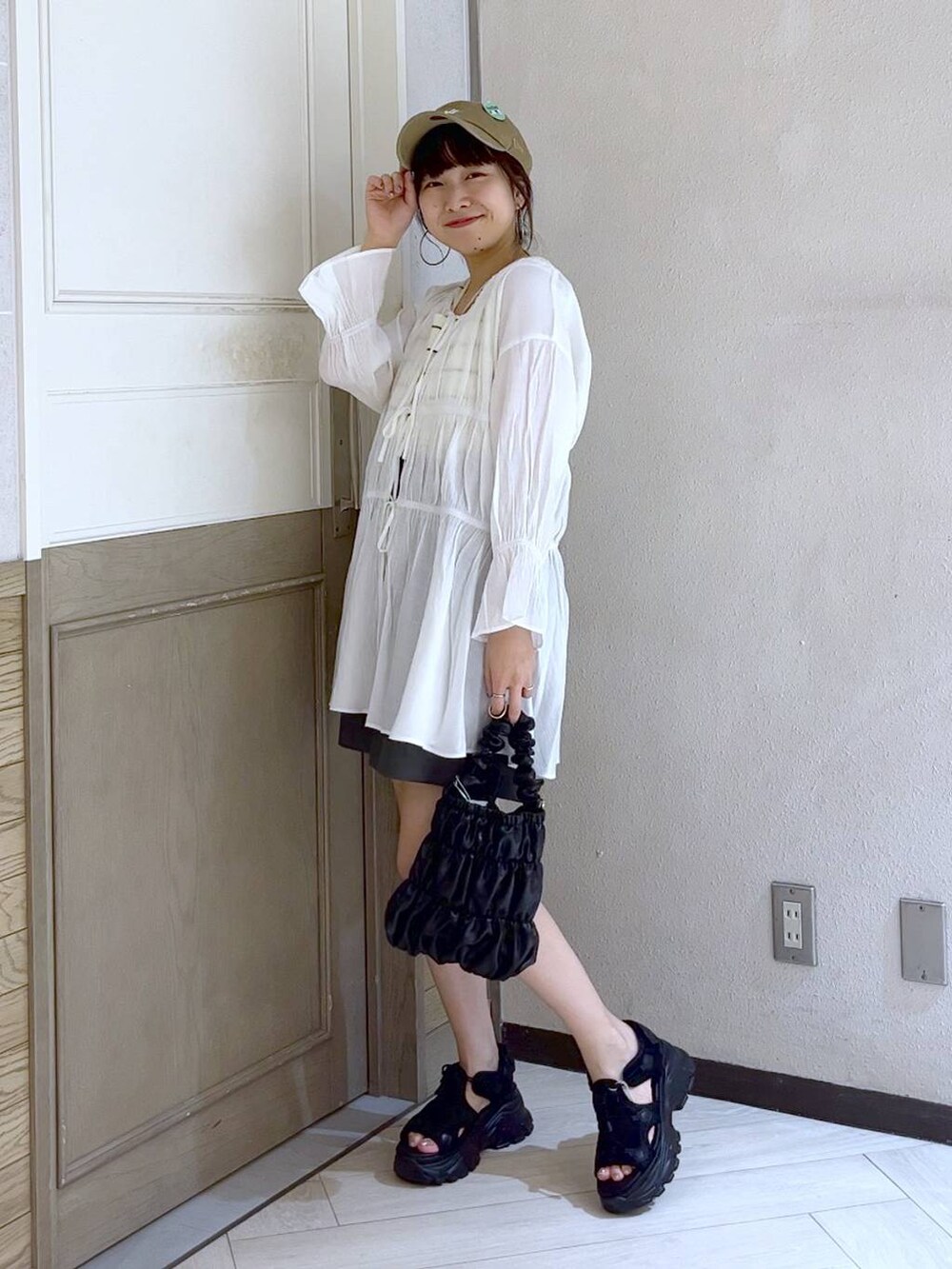 ブラック系のサンダル、ホワイト系のタンクトップ、ブラック系のショルダーバッグを着用したレディースの春コーディネートの4枚目の写真