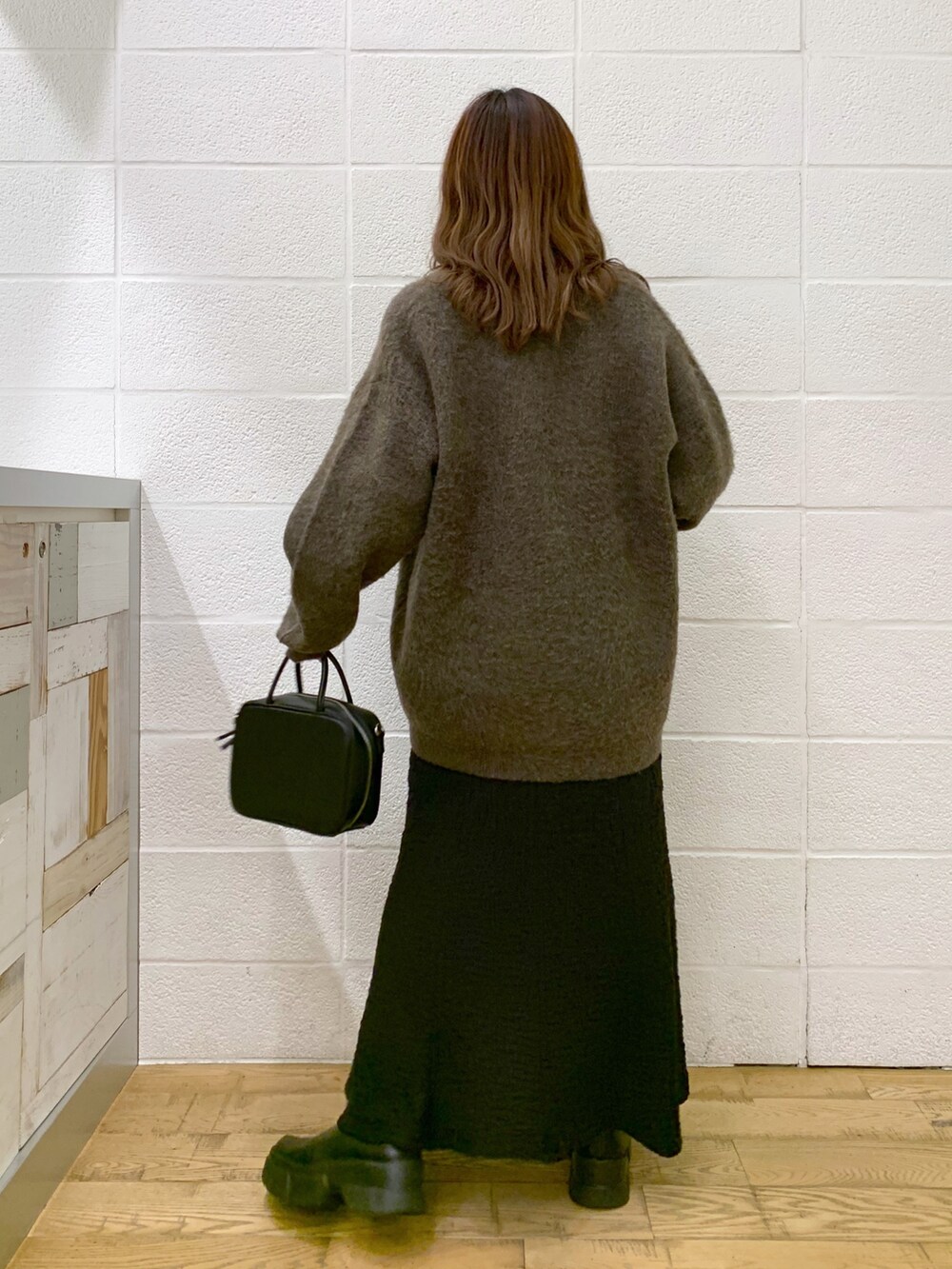 ブラウン系のカーディガン/ボレロ、ブラック系のスカート、ブラック系のバッグを着用したレディースの秋コーディネートの4枚目の写真