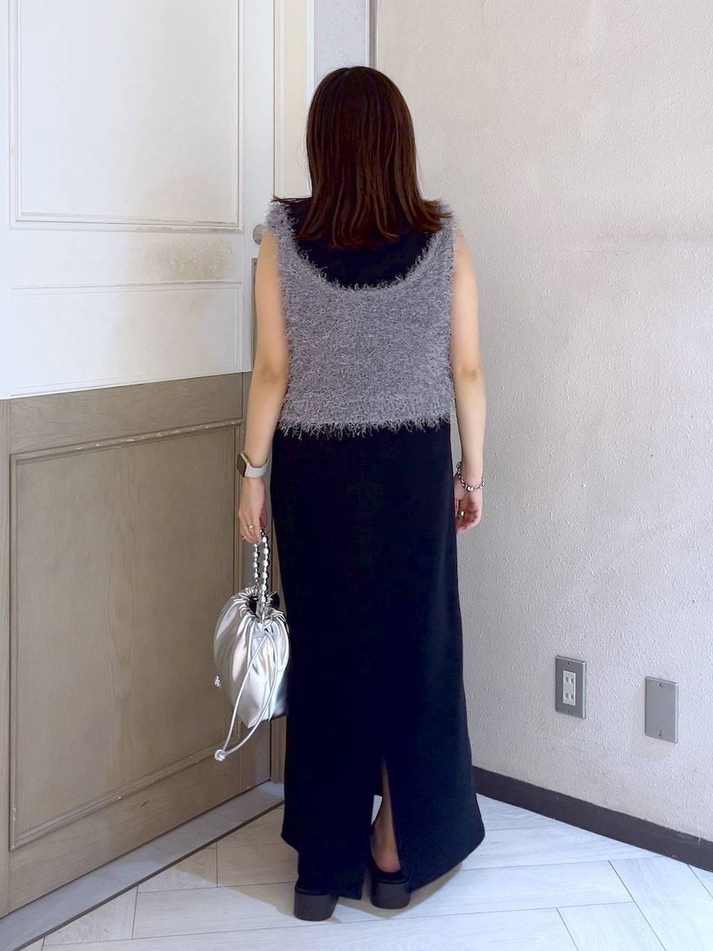 グレー系のキャミソール、ブラック系のワンピース、シルバー系のサンダルを着用したレディースの夏コーディネートの4枚目の写真