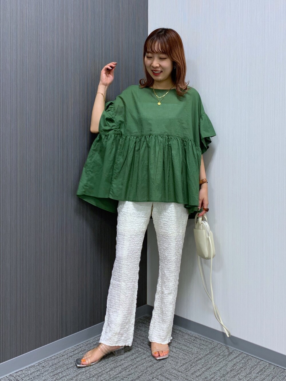 グリーン系のシャツ/ブラウス、ホワイト系のパンツ、ホワイト系のバッグを着用したレディースの秋コーディネートの2枚目の写真